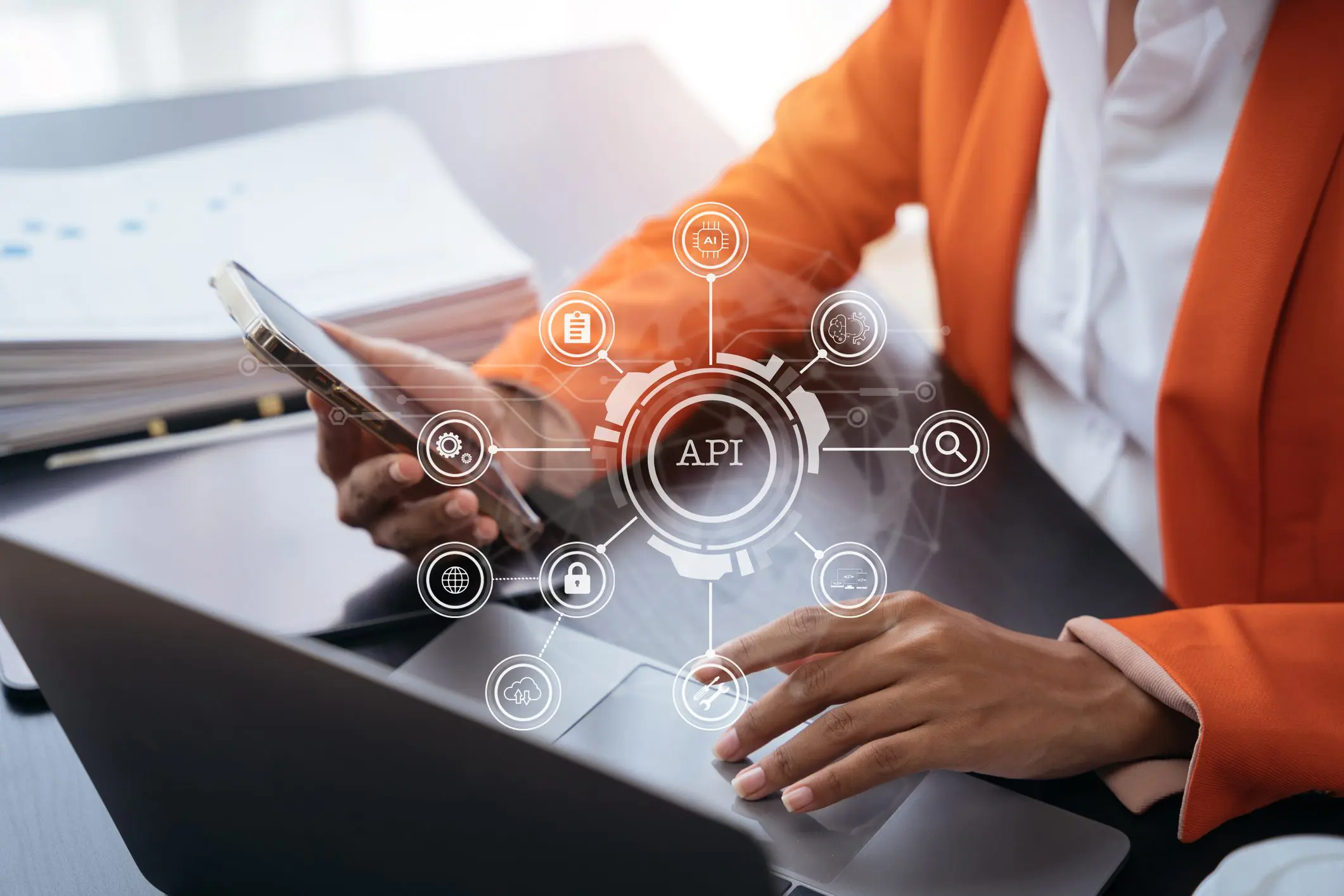 Person using laptop and smartphone with API.